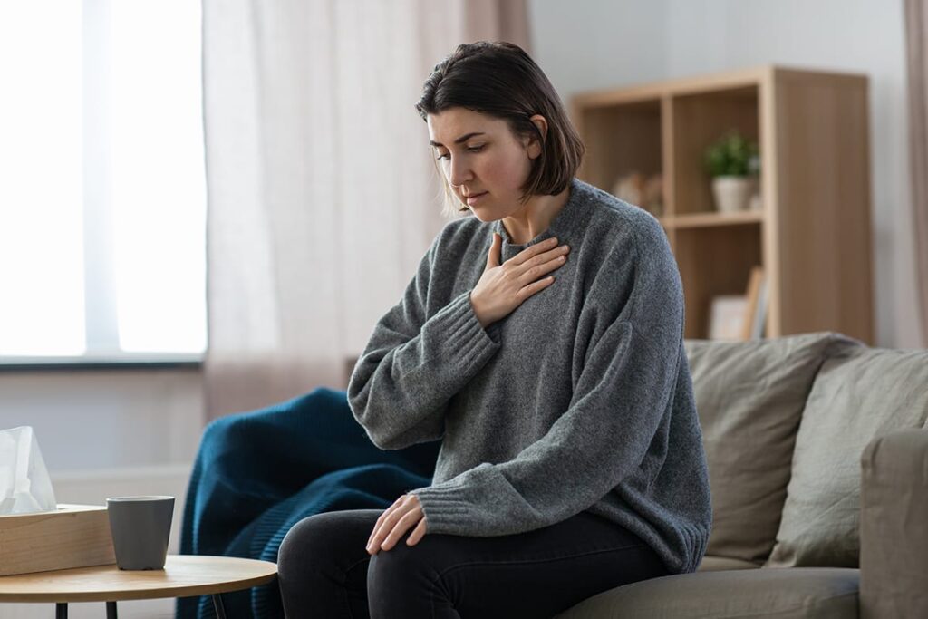 a person holds their chest while thinking of the link between drug abuse and heart failure