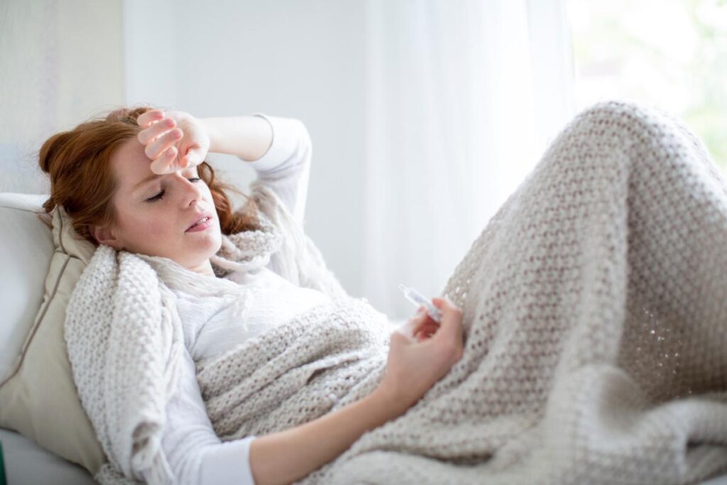 woman laying in bed experiences the signs of alcohol withdrawal