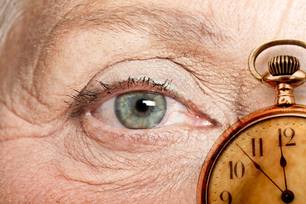 an older person looks forward from behind a clock pondering "does drinking age you?"